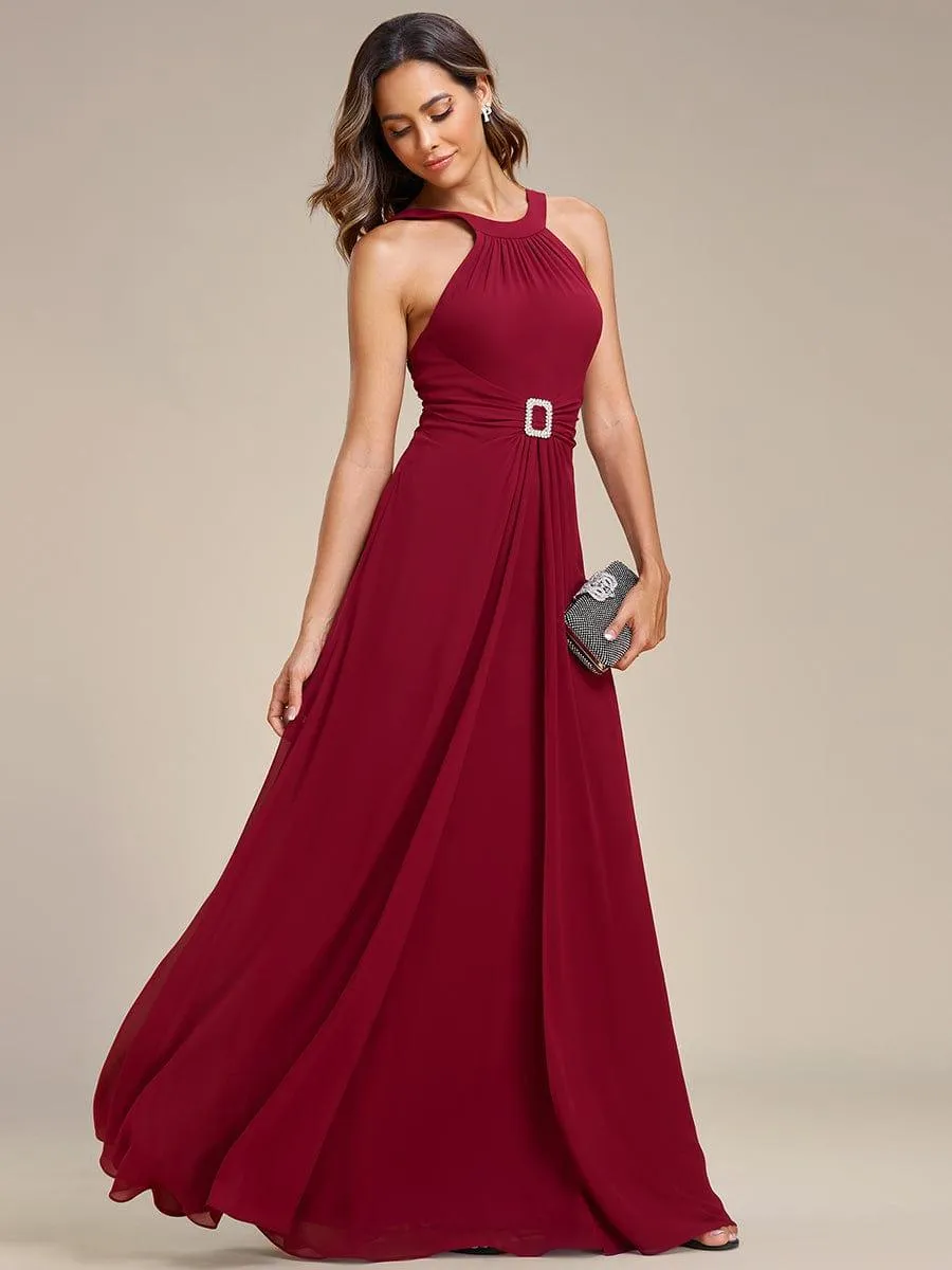 Robe longue en mousseline à col licou et taille avec diamants brillants