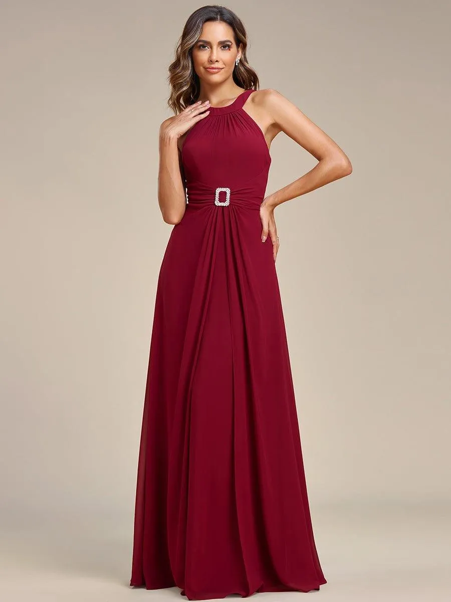 Robe longue en mousseline à col licou et taille avec diamants brillants